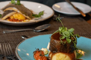 Elegant bistro dining with gourmet steak, mashed potatoes, and vibrant roasted vegetables in luxurious restaurant setting.