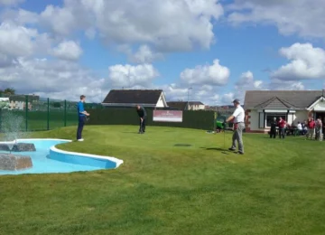 People enjoying some pitch and putt on a small pitch and putt course in the cunnigar pitch and putt club
